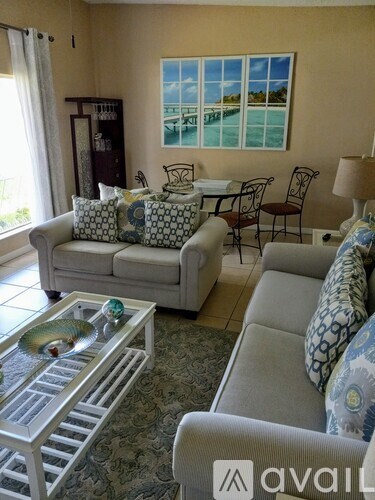 A living room with a couch, chairs, and a coffee table.