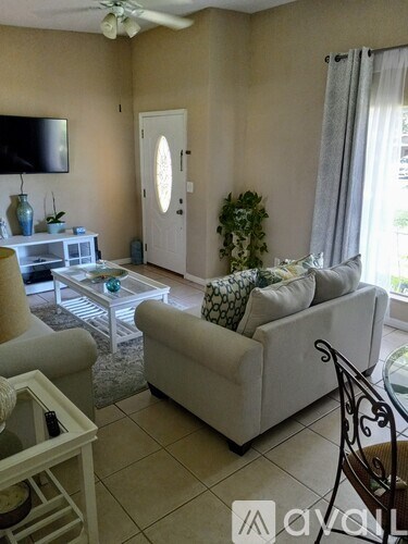 A living room with a white couch and a glass table.