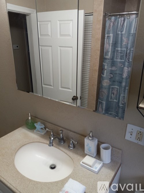 A bathroom sink with a white counter top and a white door in the background.