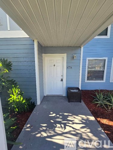 A white door is on the left side of a blue house.