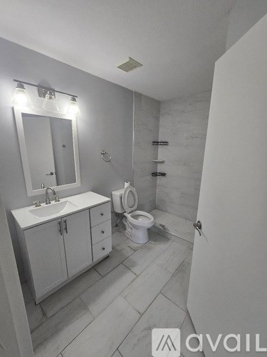A bathroom with a sink, toilet, and a mirror.