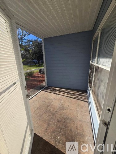 A patio area with a sliding door and a view of a backyard.