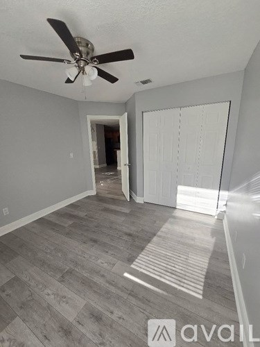 A room with a ceiling fan and a sliding door.