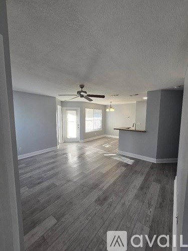 A room with wooden flooring and a ceiling fan.