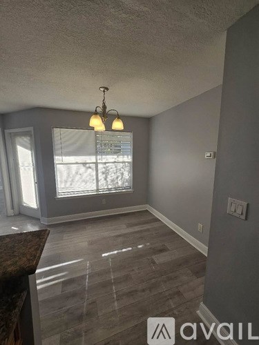 A room with a window and a chandelier.