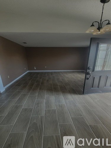 A room with wooden flooring and a door with a glass window.