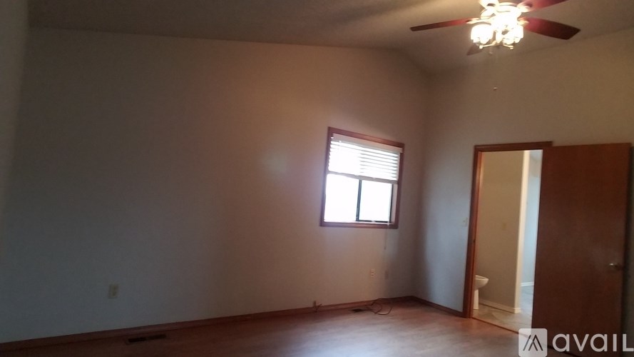 A room with a ceiling fan and a window.