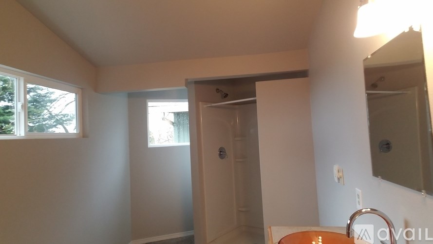 A bathroom with a toilet, sink, and mirror.