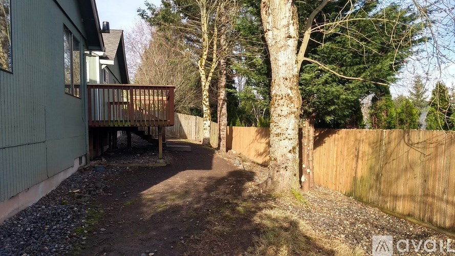 A backyard with a deck and a fence.
