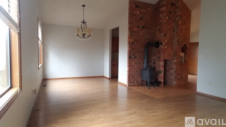 A room with wooden floors and a brick wall with a chandelier hanging from the ceiling.
