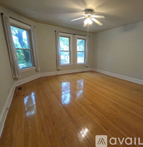 A room with wooden flooring and a ceiling fan.