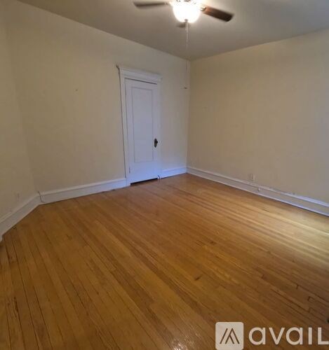 A room with wooden flooring and a white door.