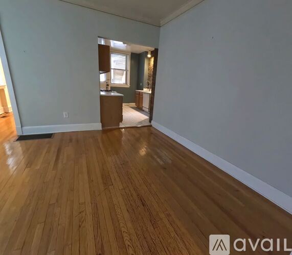 A room with wooden flooring and a cabinet in the corner.