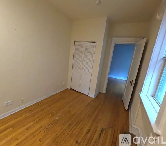 A room with wooden flooring and white walls.