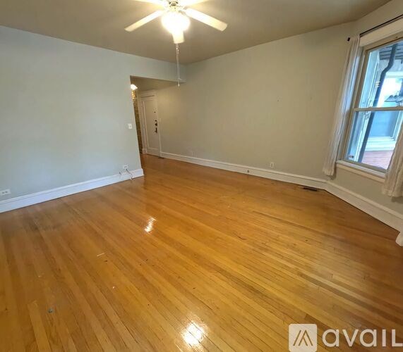 A room with wooden flooring and a ceiling fan.