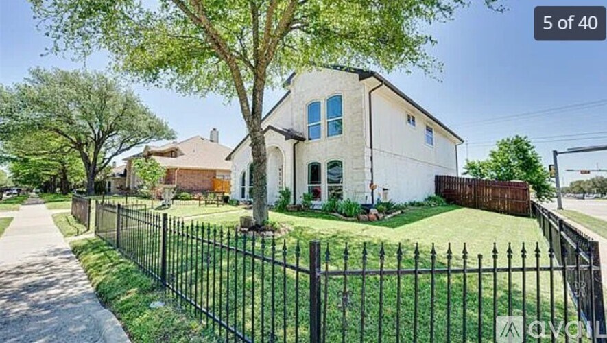 A white house with a black fence in front of it.