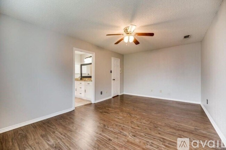 A room with wooden flooring and a ceiling fan.