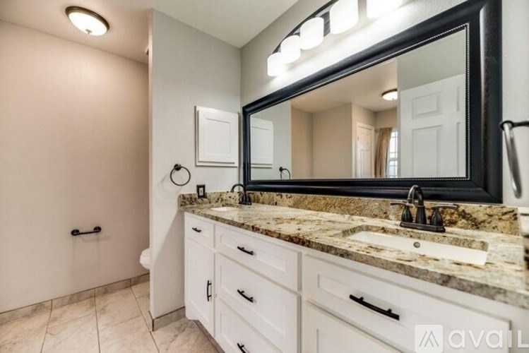A bathroom with a marble countertop and a large mirror.