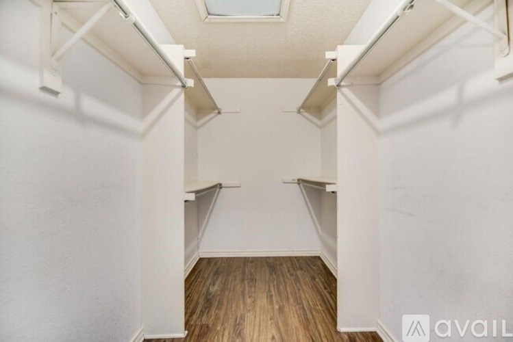 A small, empty room with wooden floors and white walls.