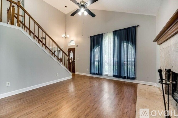 A living room with a staircase and a fireplace.