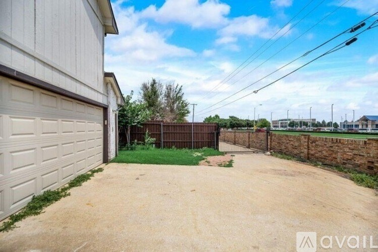 A backyard with a dirt path, a fence, and a garage.