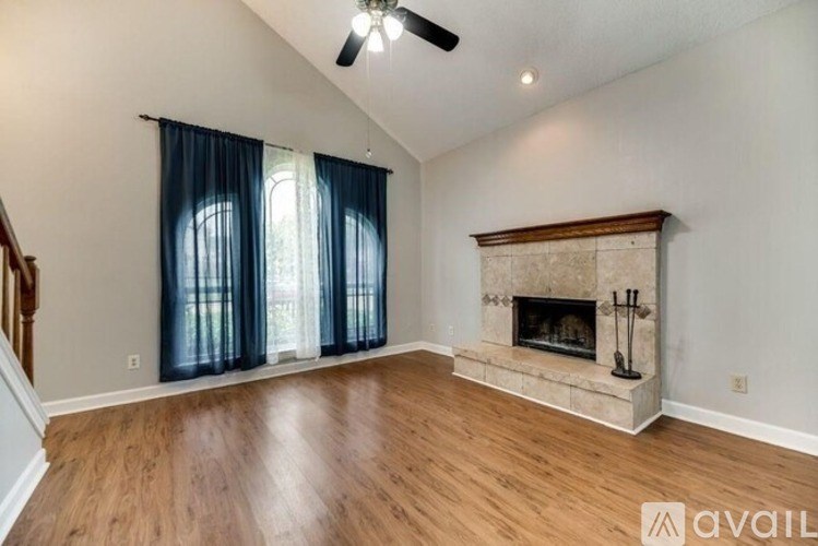A living room with a fireplace and a ceiling fan.