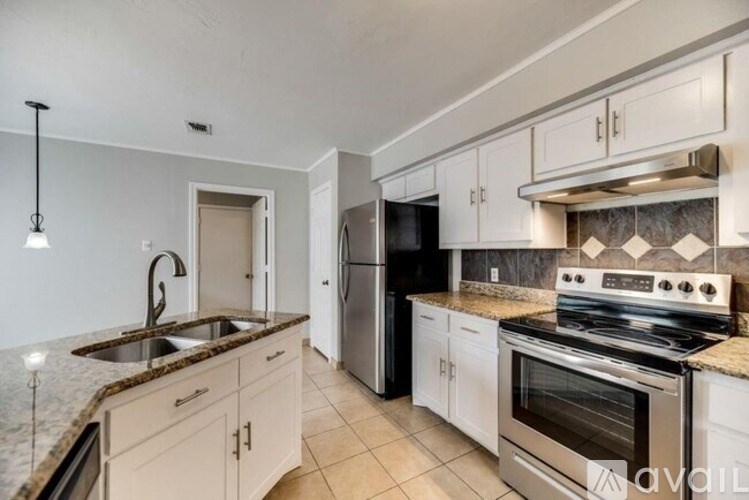 A kitchen with a granite countertop and stainless steel appliances.