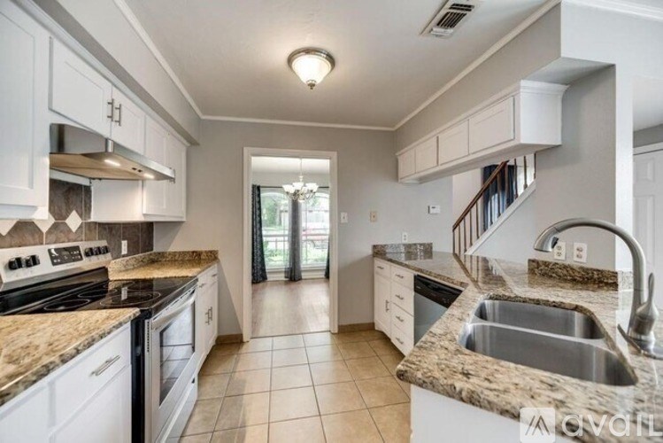 A kitchen with granite countertops and white cabinets.