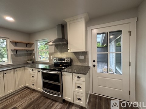 A kitchen with white cabinets and a black stove top oven.