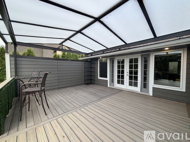 A patio with a table and chairs under a roof.