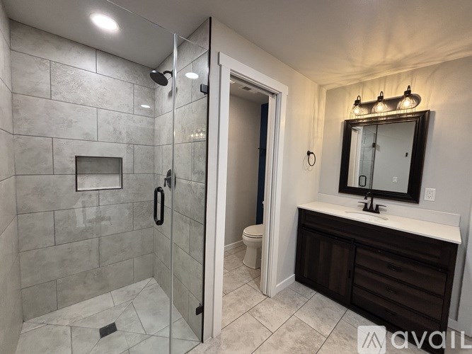 A bathroom with a walk-in shower and a sink vanity.