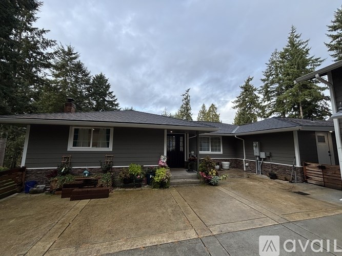 A house with a grey roof and a front yard with a planter box.