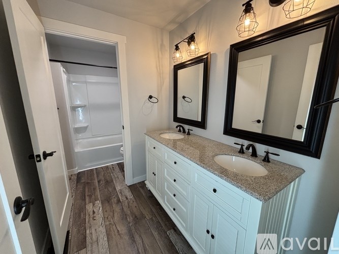 A bathroom with a white vanity and a walk-in shower.