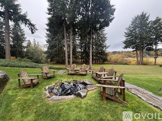 A backyard with a fire pit and chairs.