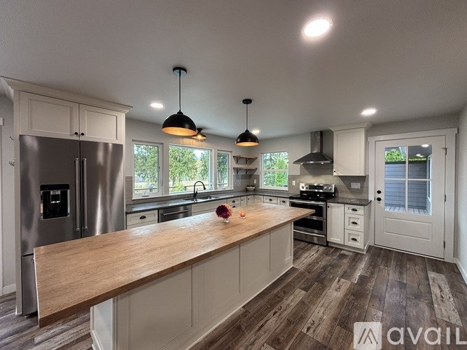 A kitchen with a wooden countertop and stainless steel appliances.