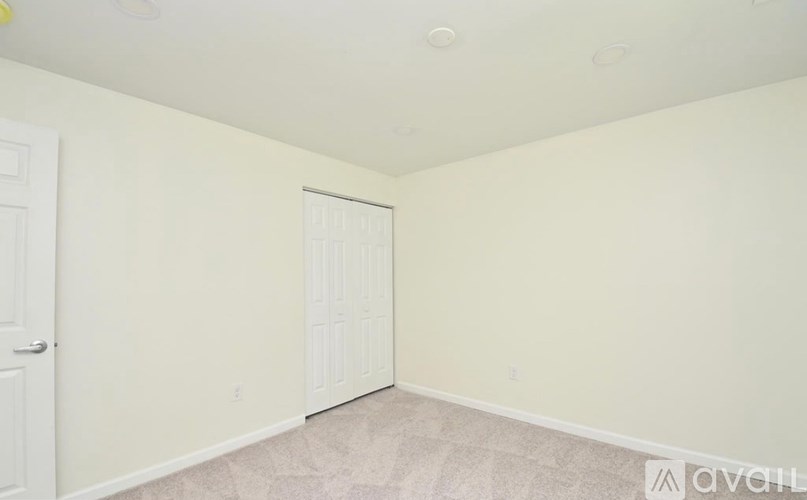 A room with a white door and carpeted floor.