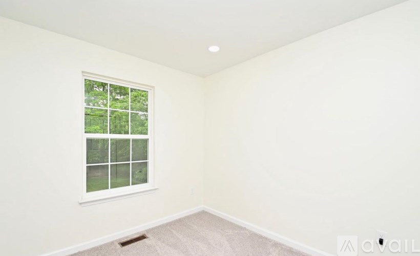 A room with a window and a carpet on the floor.
