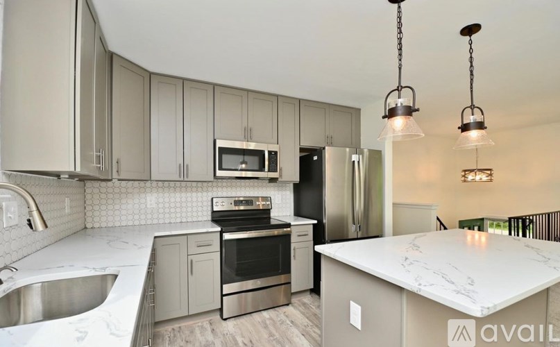 A kitchen with a marble countertop and stainless steel appliances.