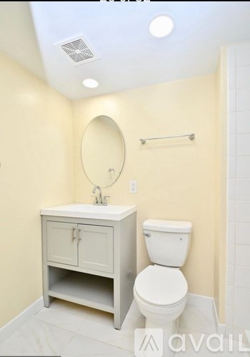 A bathroom with a toilet, sink, and a mirror.