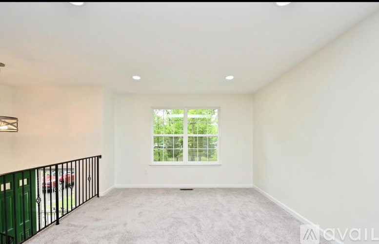 A room with a window and a carpeted floor.