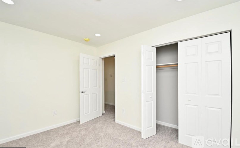 A white door is open in a room with a carpeted floor.