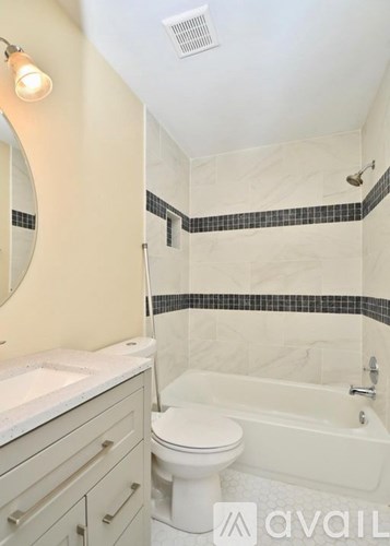 A bathroom with a toilet, sink, and bathtub.