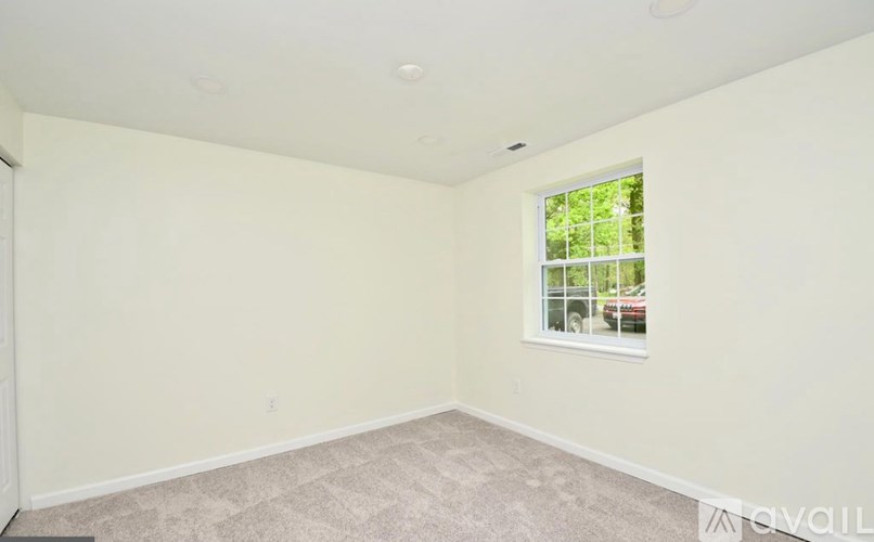 A room with a window and car view outside.