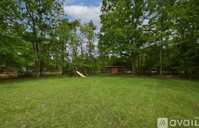 A backyard with a slide and a shed.