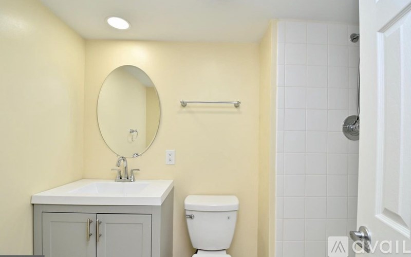 A bathroom with a toilet, sink, and mirror.