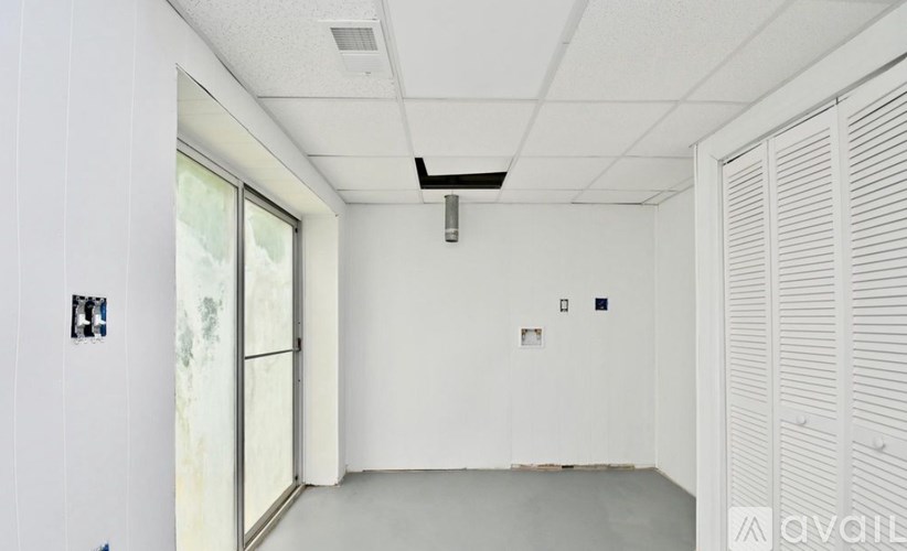 A white room with a window and a door.