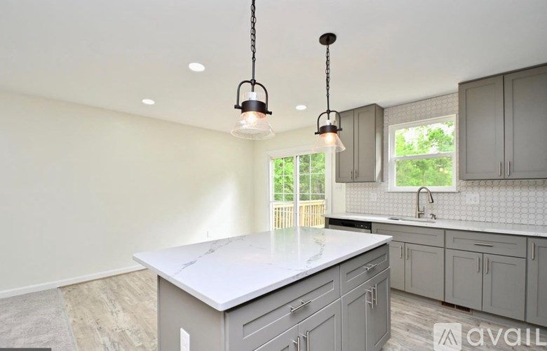 A kitchen with a white countertop and grey cabinets.