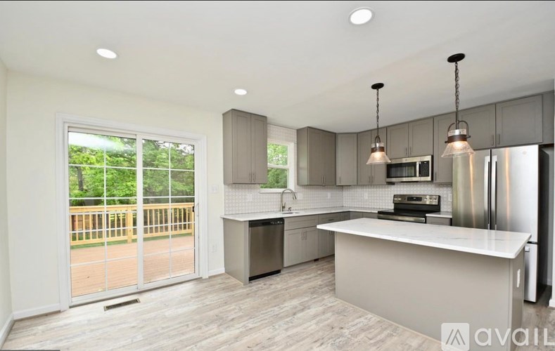 A modern kitchen with a large island and stainless steel appliances.