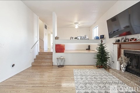 A living room with a fireplace and a television mounted on the wall.