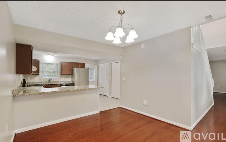 A kitchen area with a marble countertop and a hanging light fixture.